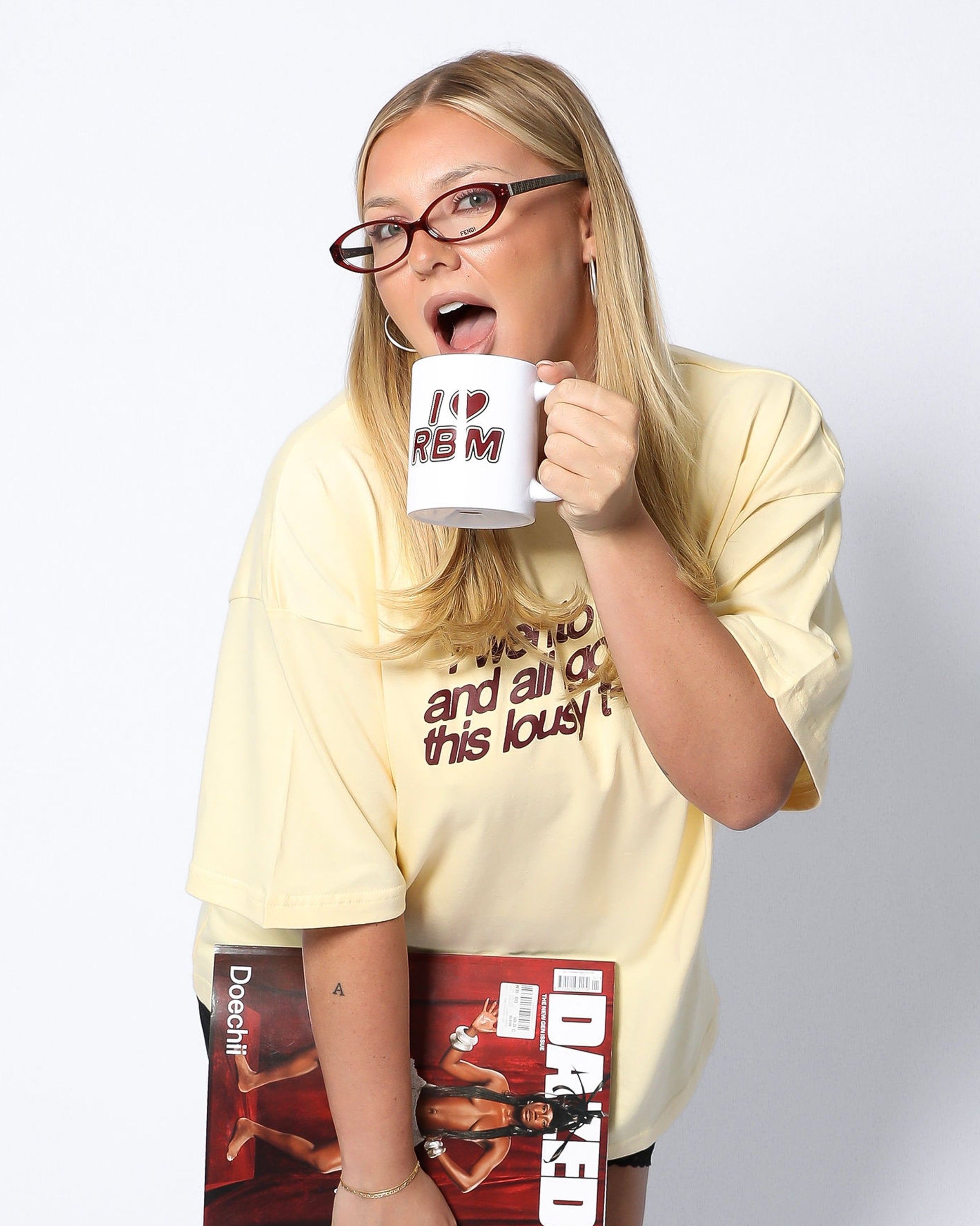 Person holding a mug and magazine with a surprised expression on a white background